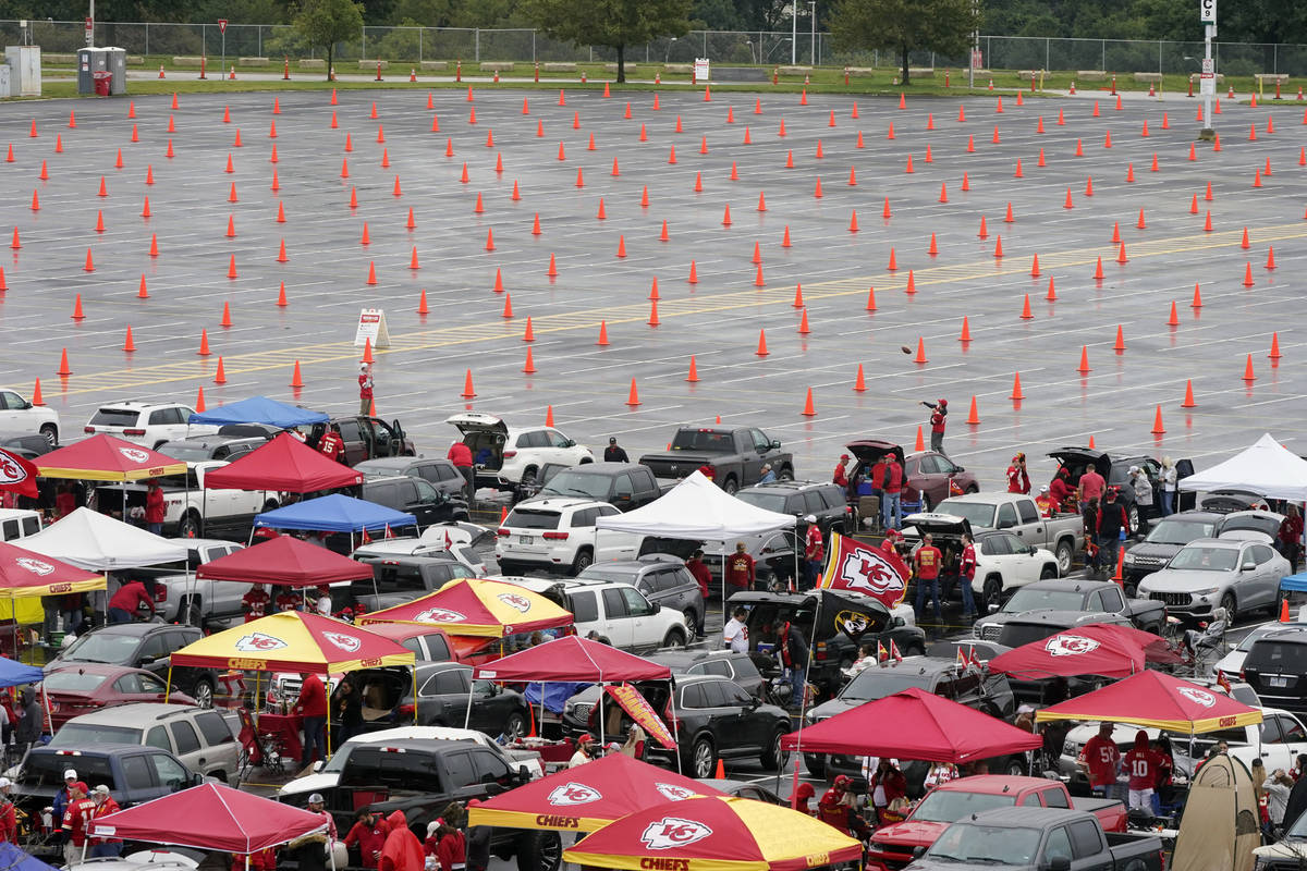 Fans tailgate in a partially filled parking lot outside Arrowhead Stadium before an NFL footbal ...
