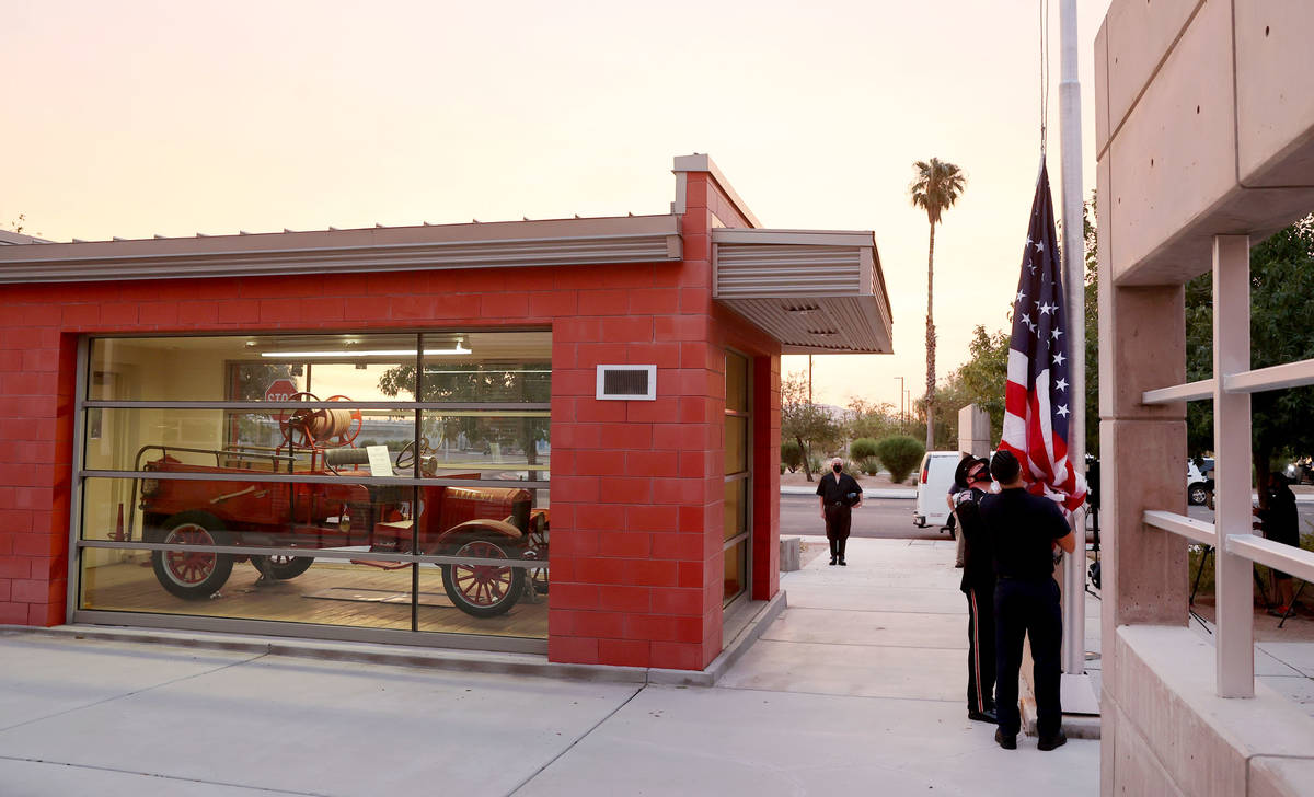 Firefighters take the flag down in preparation for raising a flag that flew at the World Trade ...