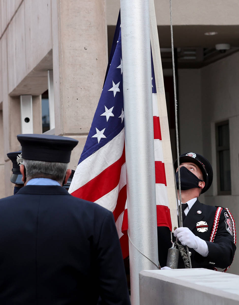 Las Vegas Fire engineer Brian Dietz prepares to raise a flag that flew at the World Trade Cente ...