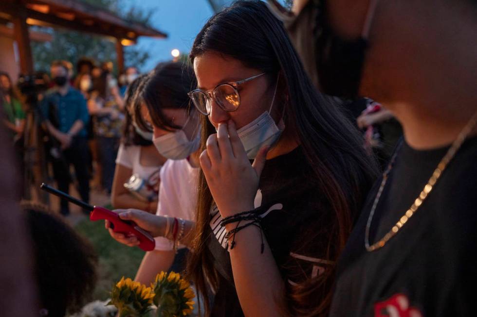 Sister of victim Lesly Palacio, Nayelli Palacio, 16, wipes her tears while she lights candles d ...