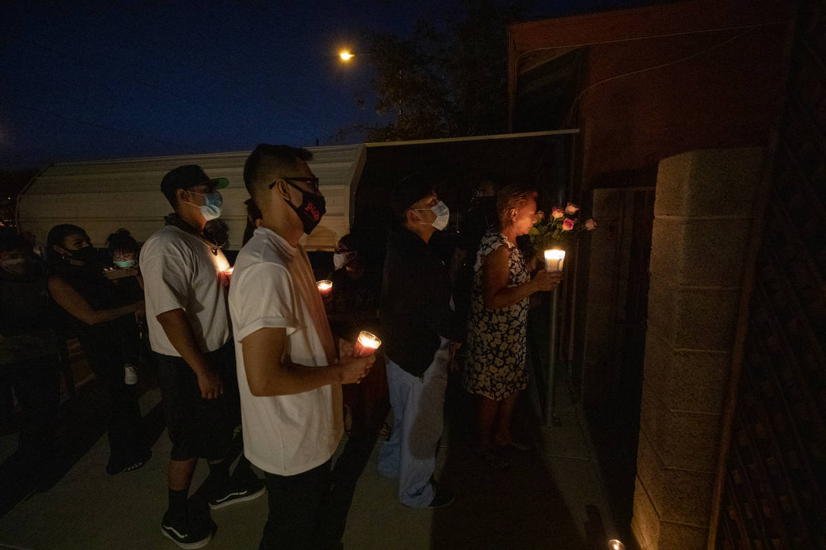 Individuals stand outside of a vigil held for Lesly Palacio, at her mother's home in Las Vegas ...