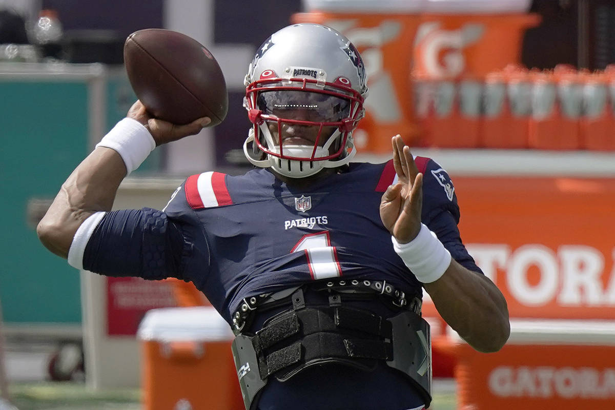 New England Patriots quarterback Cam Newton warms up before an NFL football game against the Mi ...