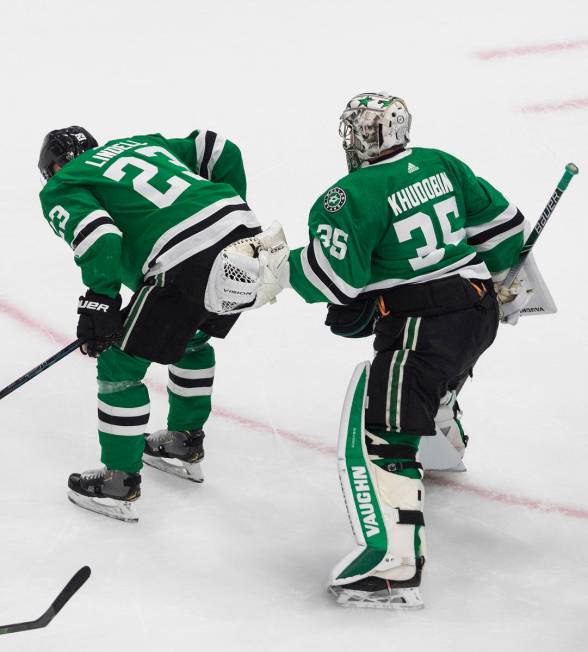 Dallas Stars defenseman Esa Lindell (23) is helped off the ice by goalie Anton Khudobin (35) af ...