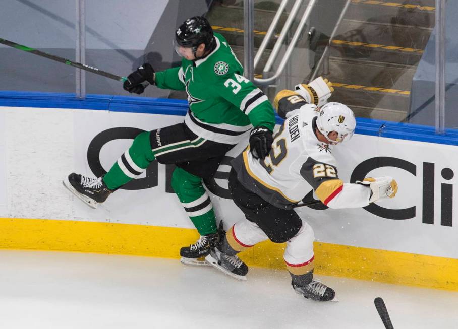 Dallas Stars right wing Denis Gurianov (34) checks Vegas Golden Knights defenceman Nick Holden ...