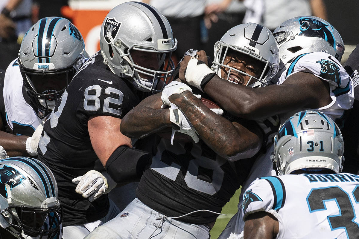 Las Vegas Raiders running back Josh Jacobs (28) is stacked up by Carolina Panther defenders in ...