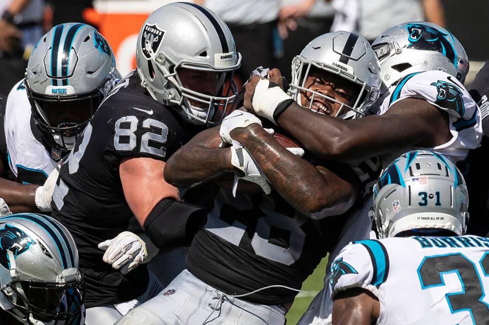 Las Vegas Raiders running back Josh Jacobs (28) is stacked up by Carolina Panther defenders in ...