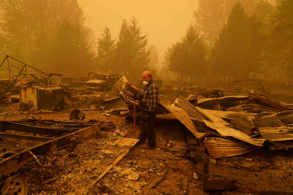 George Coble walks through what remains of a home on his property destroyed by a wildfire Satur ...