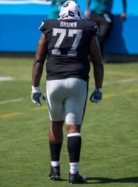 Las Vegas Raiders offensive tackle Trent Brown (77) walks off the field with a trainer after th ...