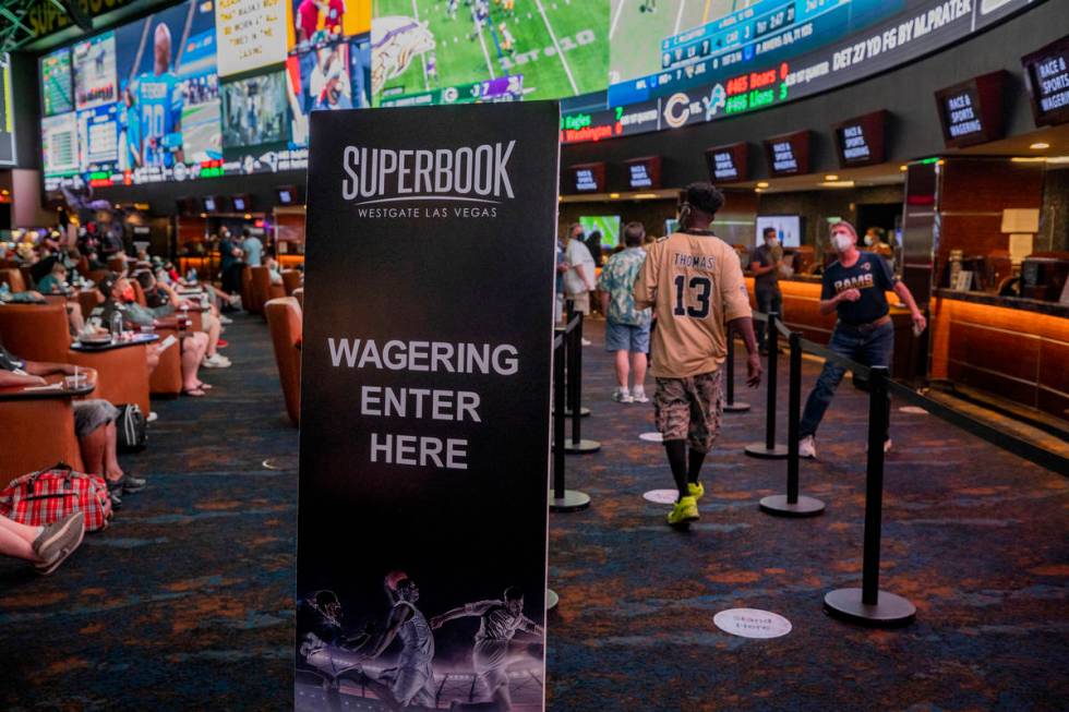 Individuals watch games and place bets at the Westgate Sportsbook during opening weekend, in La ...