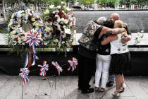 Mourners hug beside the names of the deceased Jesus Sanchez and Marianne MacFarlane at the Nati ...