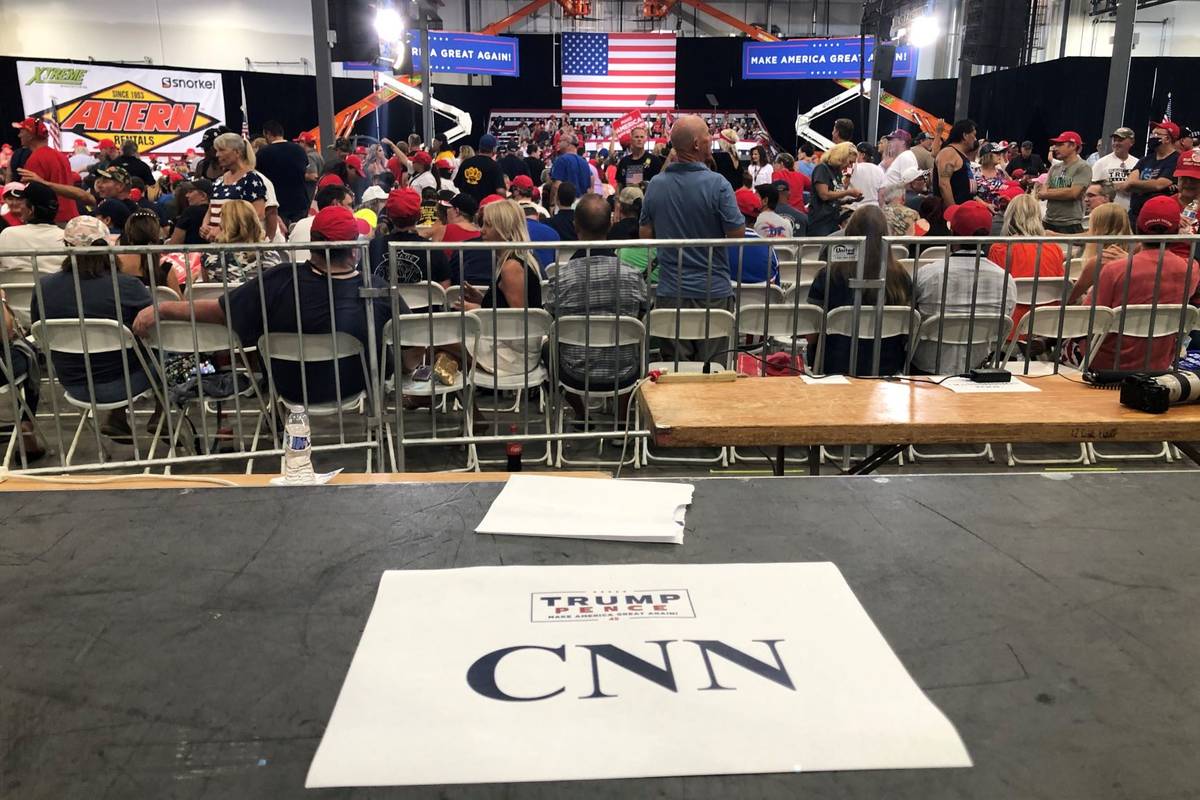 Supporters of President Donald Trump sit in front of an empty CNN media riser before a campaign ...