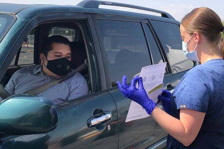 Registered nurse Valerie Farrar explains COVID-19 information to Vincent Nava after his self-ad ...