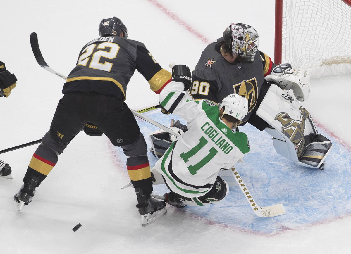 Dallas Stars' Andrew Cogliano (11) and Vegas Golden Knights' Nick Holden (22) battle in front o ...