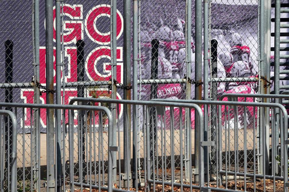 A mural showing Nebraska football players and Go Big Red lettering are seen past locked gates a ...