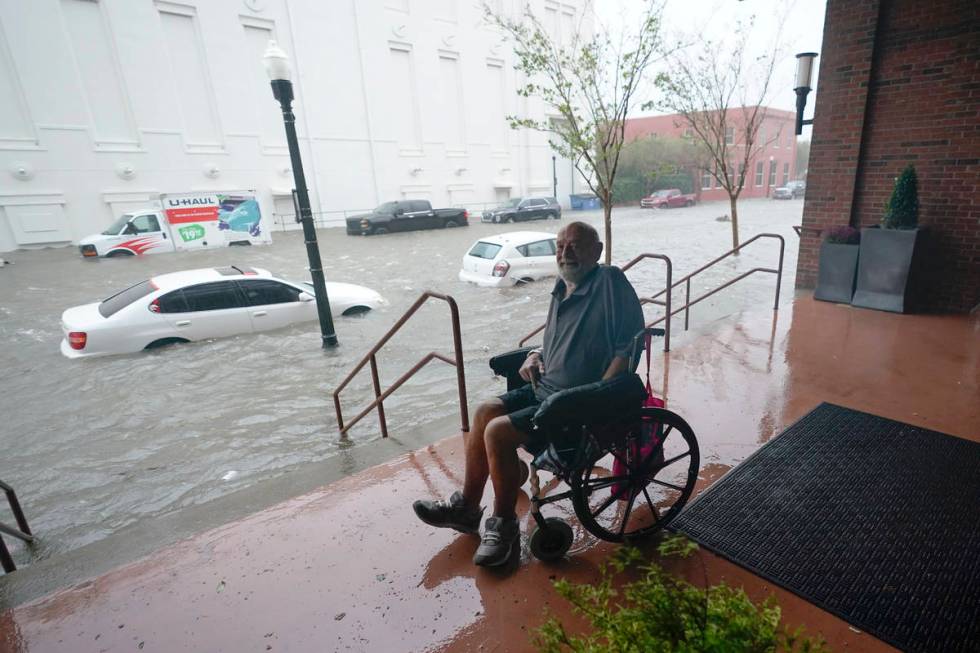 A man watches flood waters, Wednesday, Sept. 16, 2020, in downtown Pensacola, Fla. Hurricane Sa ...