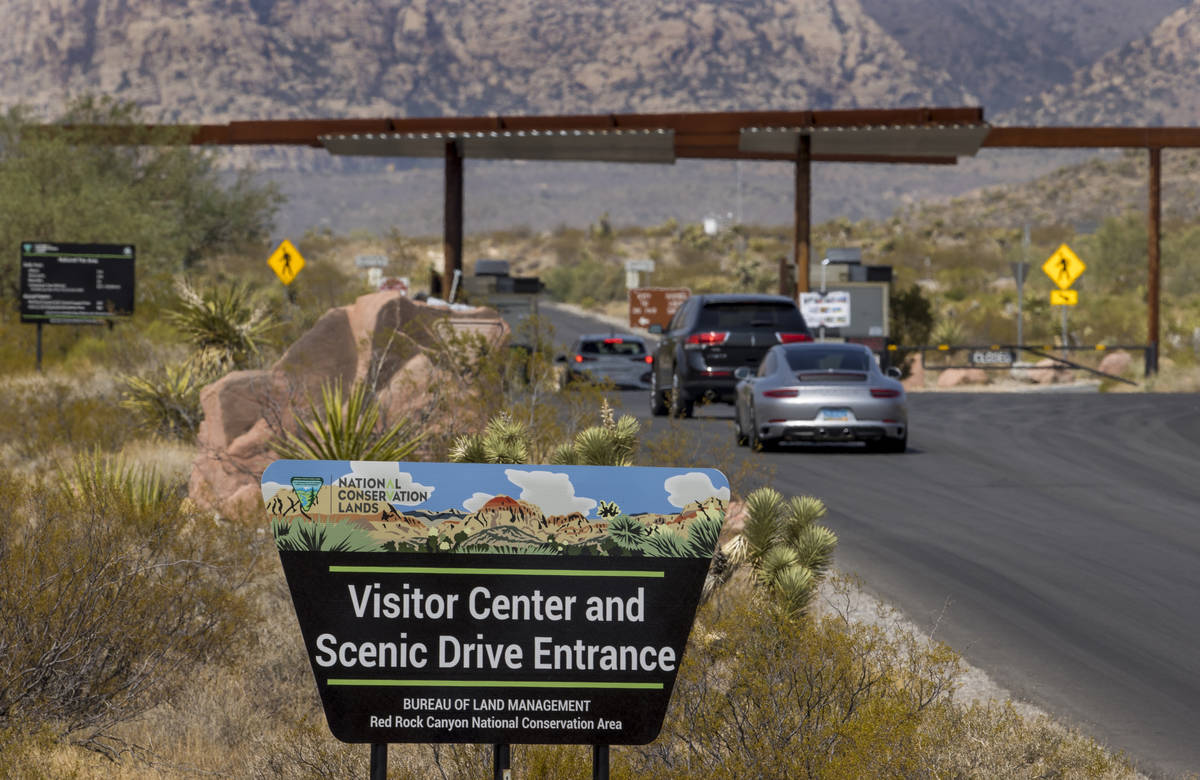 An entrance marker and vehicles for the Red Rock Canyon National Recreation Area near Las Vegas ...