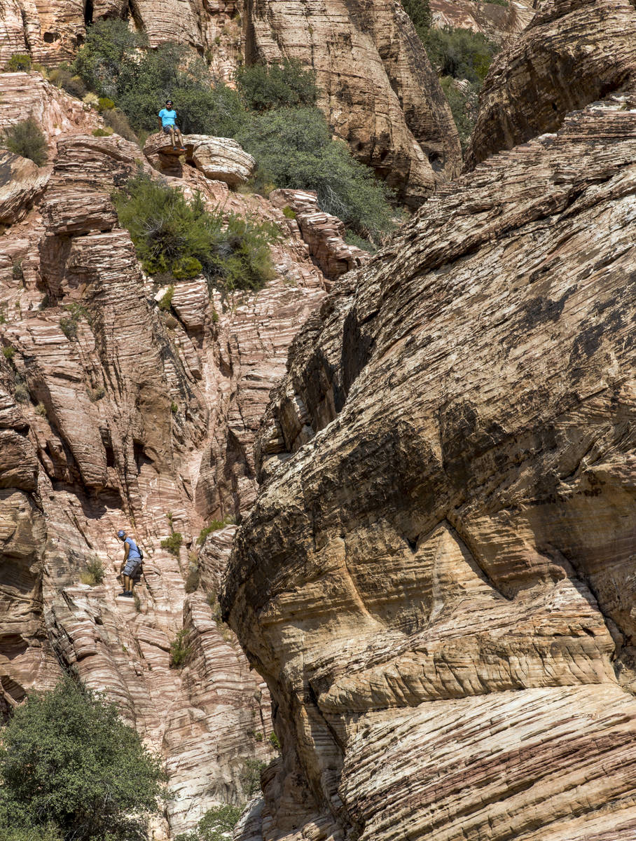 Fernando Espinosa, top, and Cesar Garcia of Chicago scale a ridge line about the Calico 1 trail ...