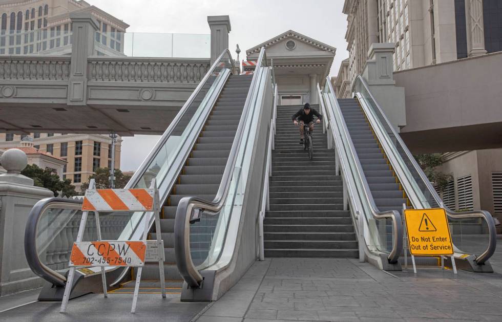 Las Vegan Matt Cremeans bikes down stairs of a pedestrian bridge on the Strip on Wednesday, Mar ...