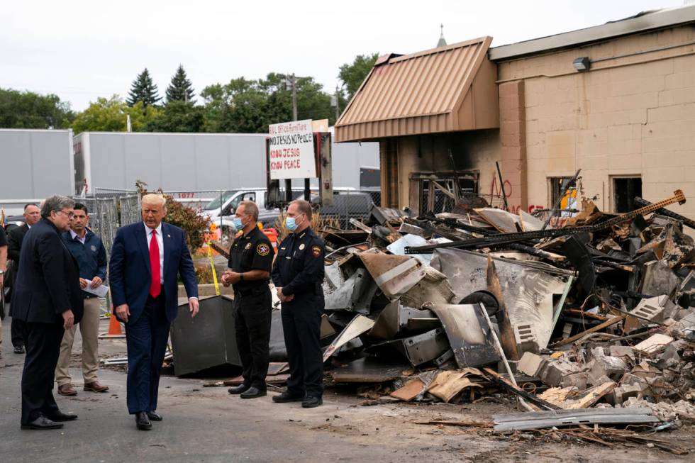 President Donald Trump walks Tuesday, Sept. 1, 2020, as he tours an area damaged during demonst ...