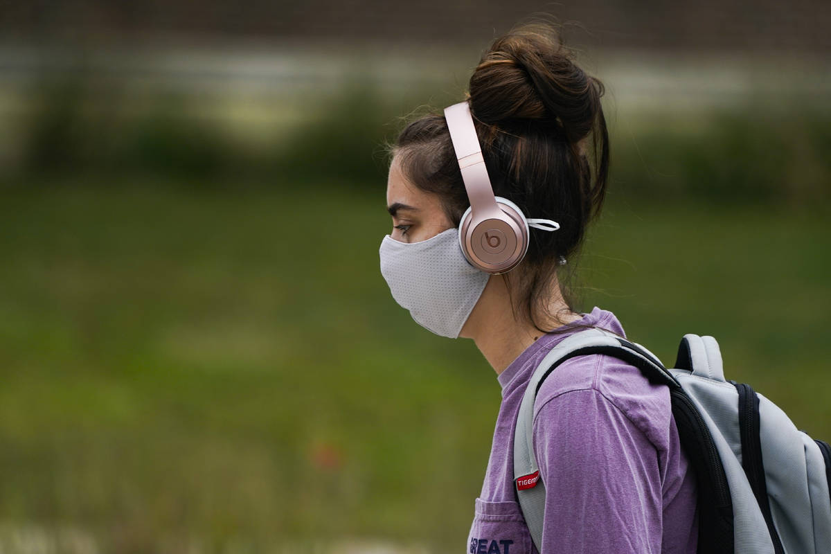 A masked student walks through the campus of Ball State University in Muncie, Ind., Thursday, S ...