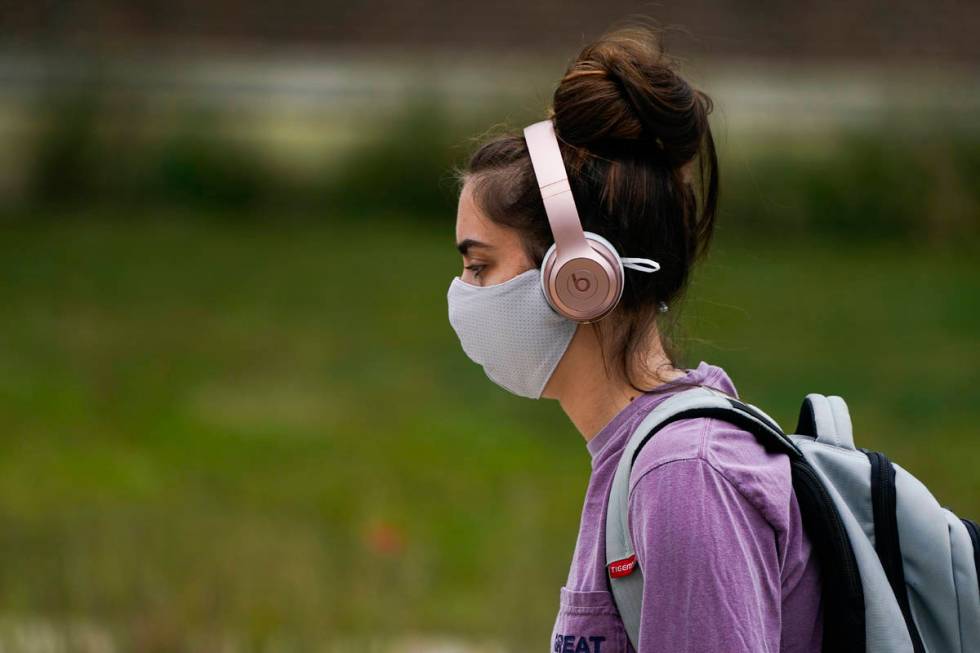 A masked student walks through the campus of Ball State University in Muncie, Ind., Thursday, S ...