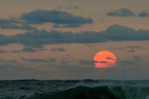 This photo taken at sunrise from Surf City on Long Beach Island in New Jersey shows the sun shr ...