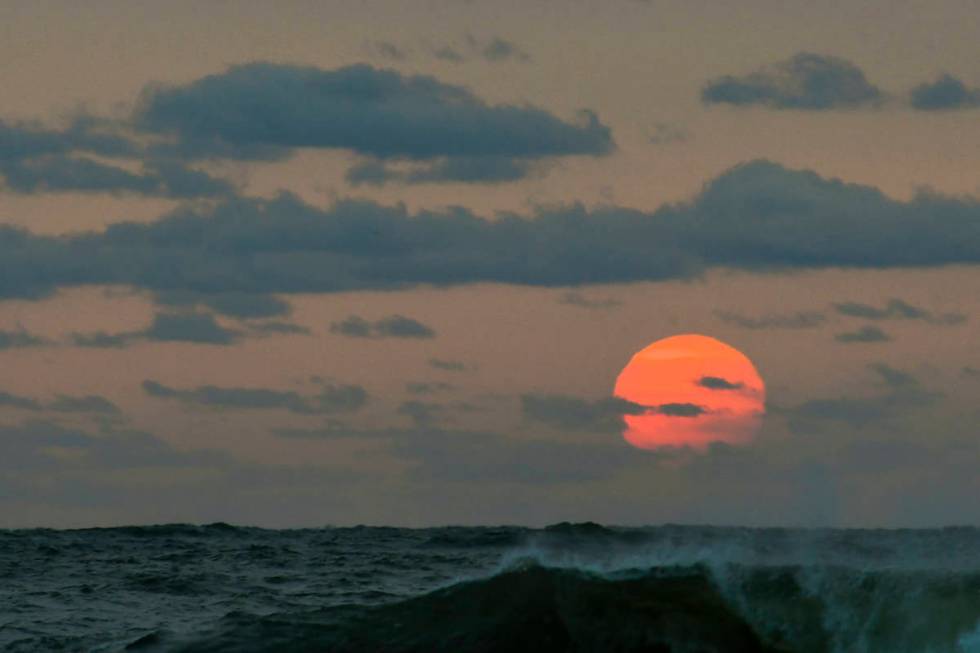 This photo taken at sunrise from Surf City on Long Beach Island in New Jersey shows the sun shr ...