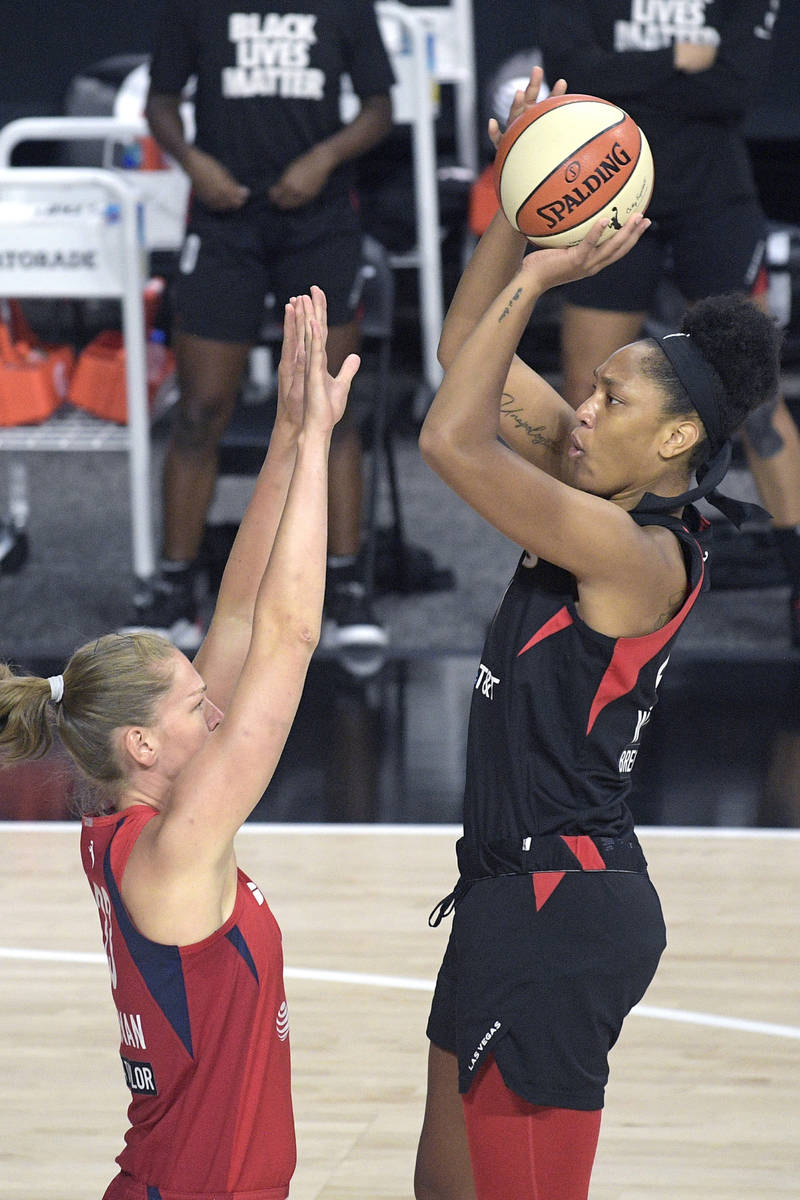 Las Vegas Aces center A'ja Wilson, right, goes up for a shot in front of Washington Mystics gua ...