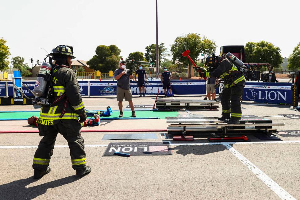 North Las Vegas firefighter paramedic Joshua Pulley, right, competes in the Firefighter Combat ...