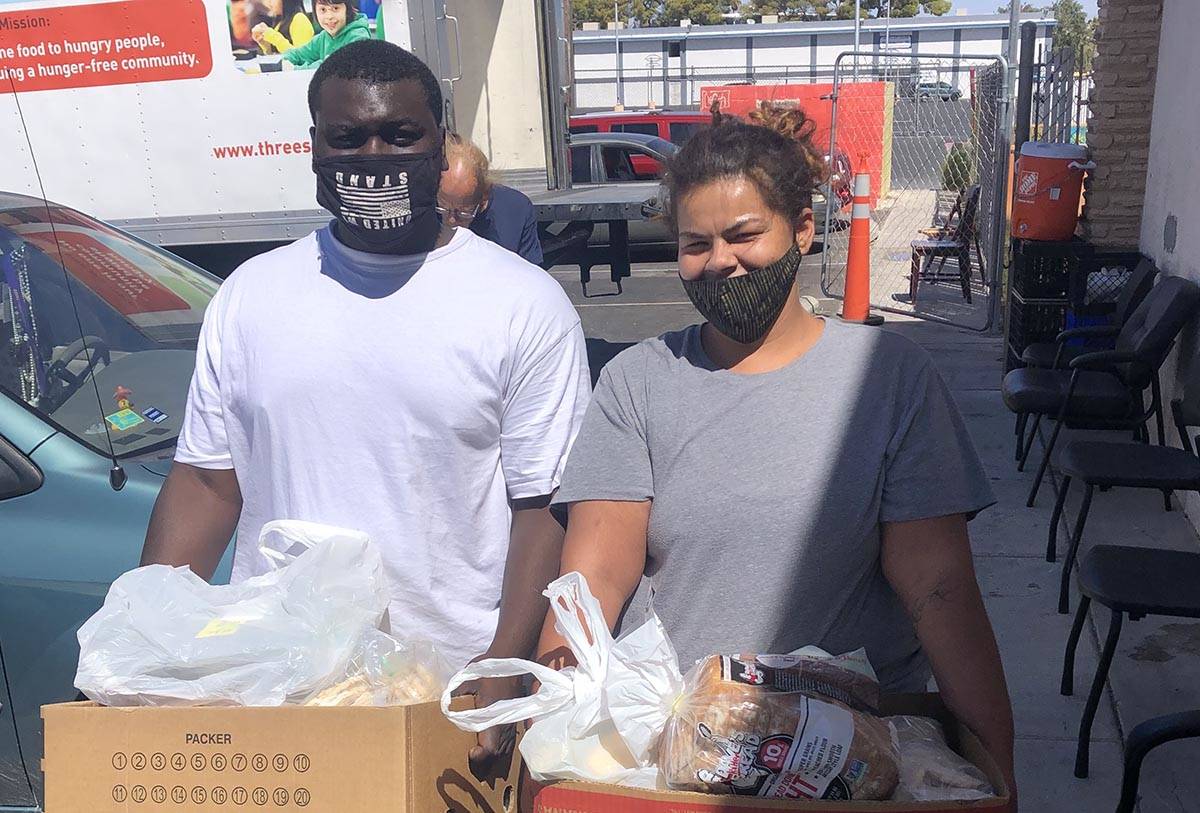 Lekarrie Evans and Lache Campbell pose with the food they received from City Impact's food bank ...
