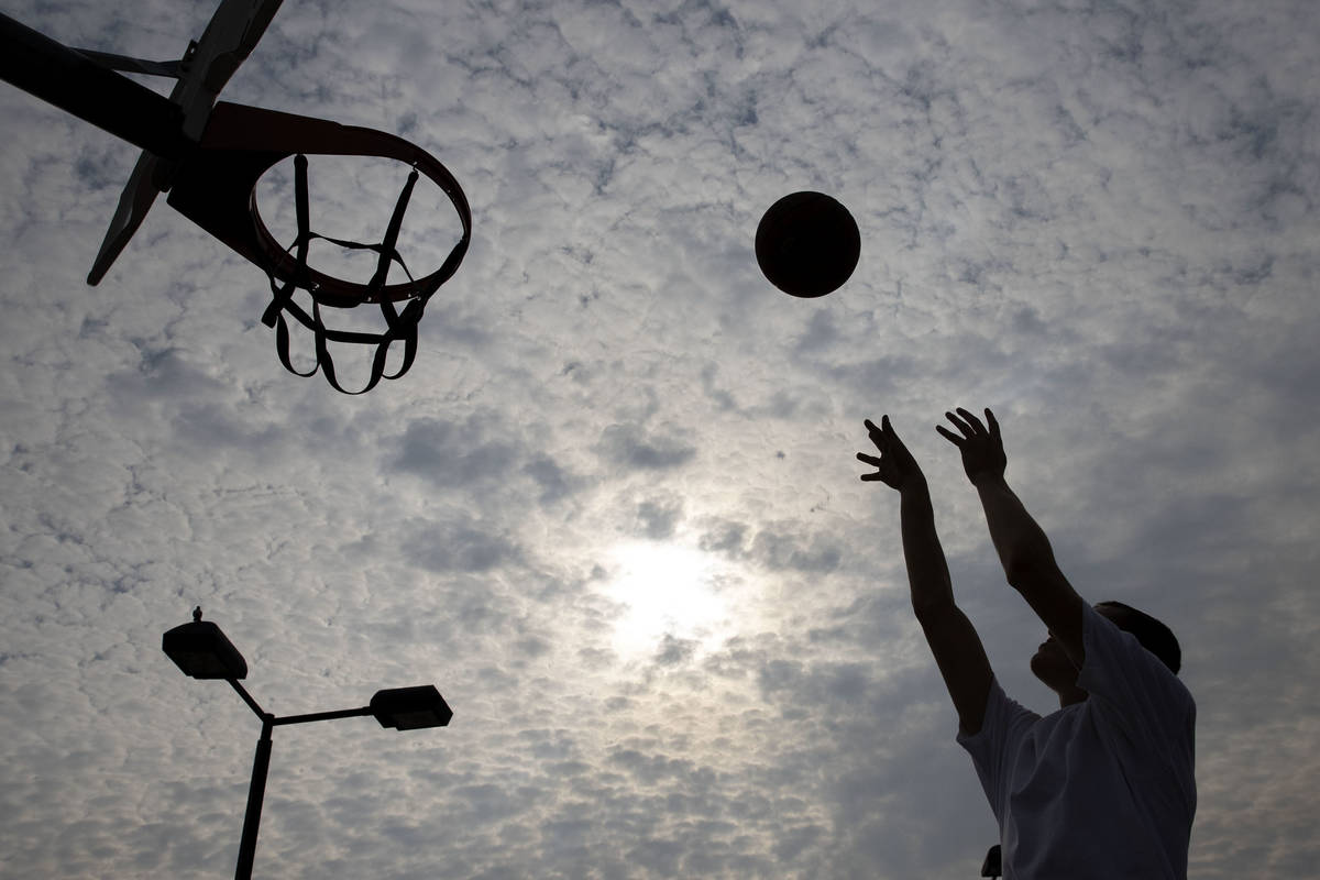 Matthew Chavez is silhouetted as he plays basketball at Charlie Frias Park, on Friday, Sept. 18 ...