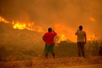 People take photos as the Bobcat Fire burns in Juniper Hill, Calif., Friday, Sept. 18, 2020. (A ...