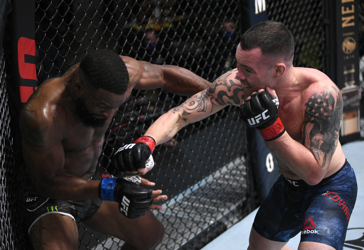 Colby Covington, right, punches Tyron Woodley in their welterweight bout during the UFC Fight N ...