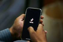 FILE - In this July 21, 2020 file photo, a man opens social media app 'TikTok' on his cell phon ...