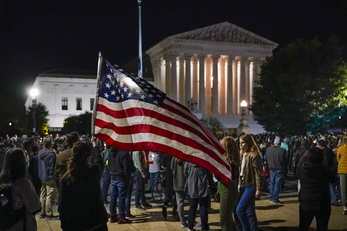 People gather at the Supreme Court in Washington, Saturday night, Sept. 19, 2020, to honor the ...