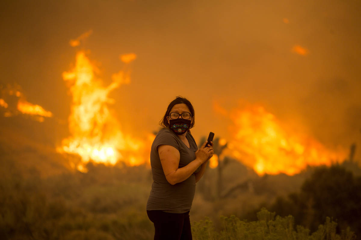 A woman watches as the Bobcat Fire burns in Juniper Hill, Calif., Friday, Sept. 18, 2020. (AP P ...