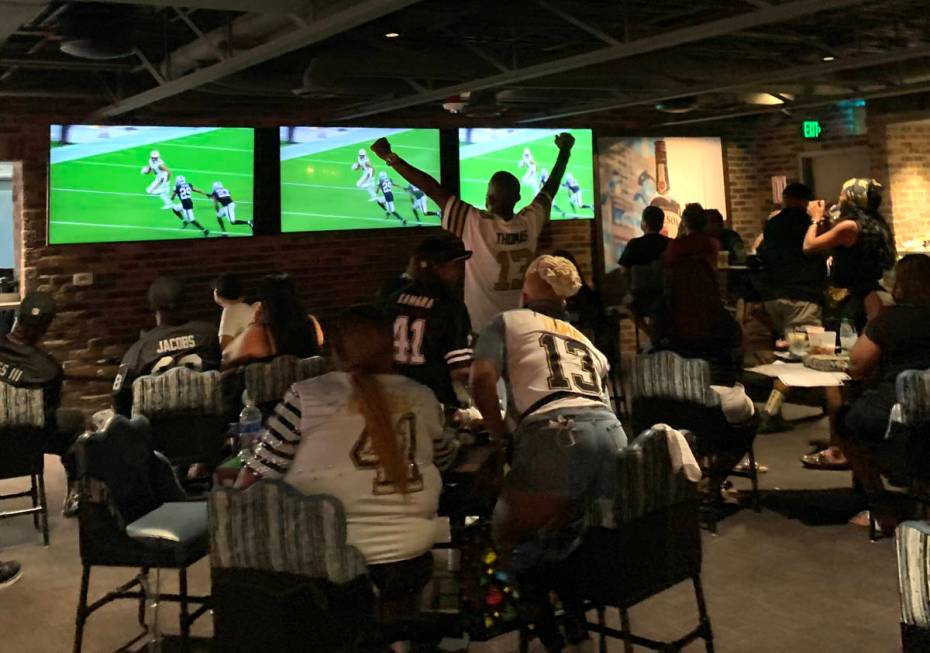 Saints fans applaud during a game at Whiskey Licker Up at Binion's on the Fremont Street Experi ...