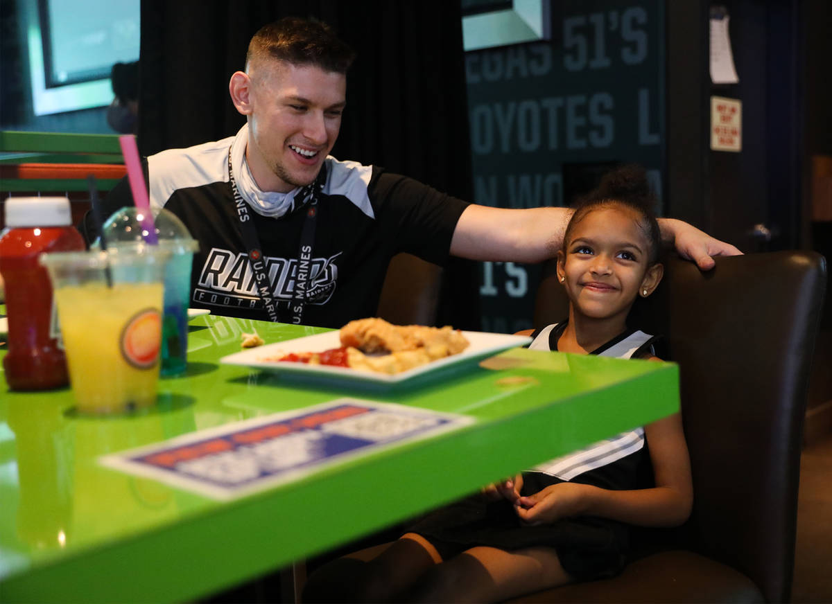 John Woodward watches the Raiders first home game with his daughter Zoe Woodward, 5, at Dave an ...