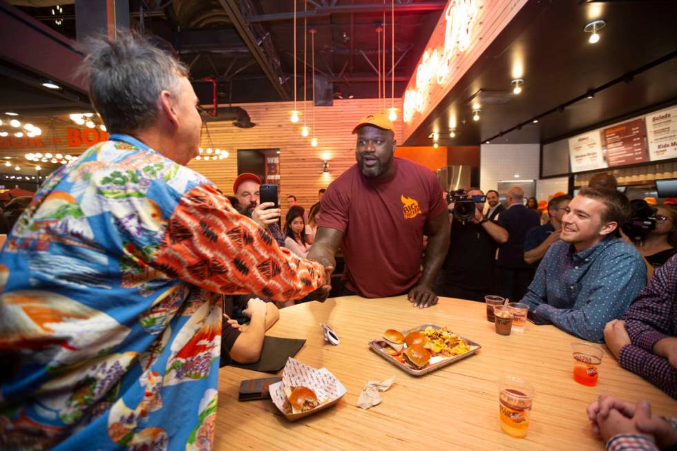 Retired NBA player Shaquille O'Neal, center, greets guests during the grand opening celebration ...