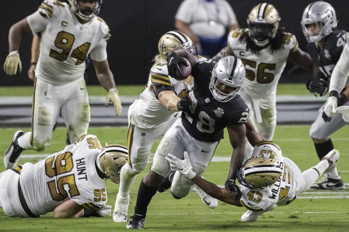 Las Vegas Raiders running back Josh Jacobs (28) breaks free from New Orleans Saints defensive e ...