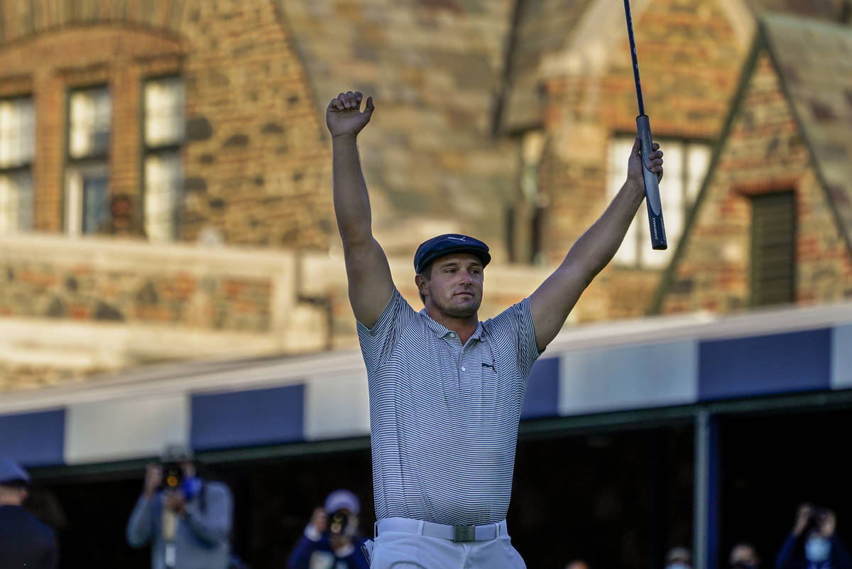 Bryson DeChambeau, of the United States, reacts after sinking a putt for par on the 18th hole t ...