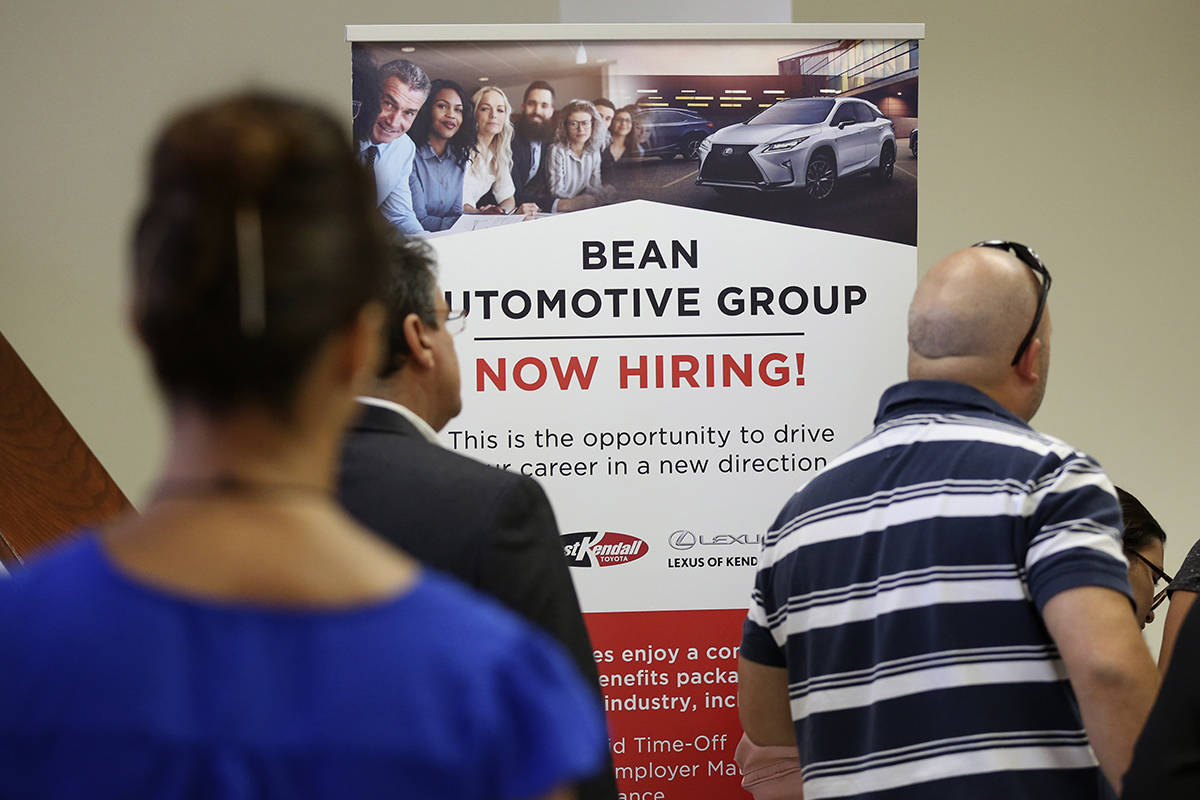 FILE - In this Sept. 18, 2019, file photo people stand in line to inquire about jobs available ...