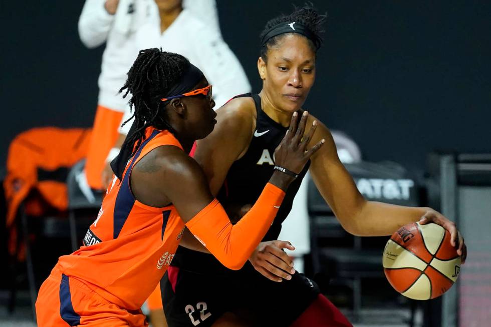 Las Vegas Aces center A'ja Wilson (22) drives around Connecticut Sun guard Essence Carson (17) ...