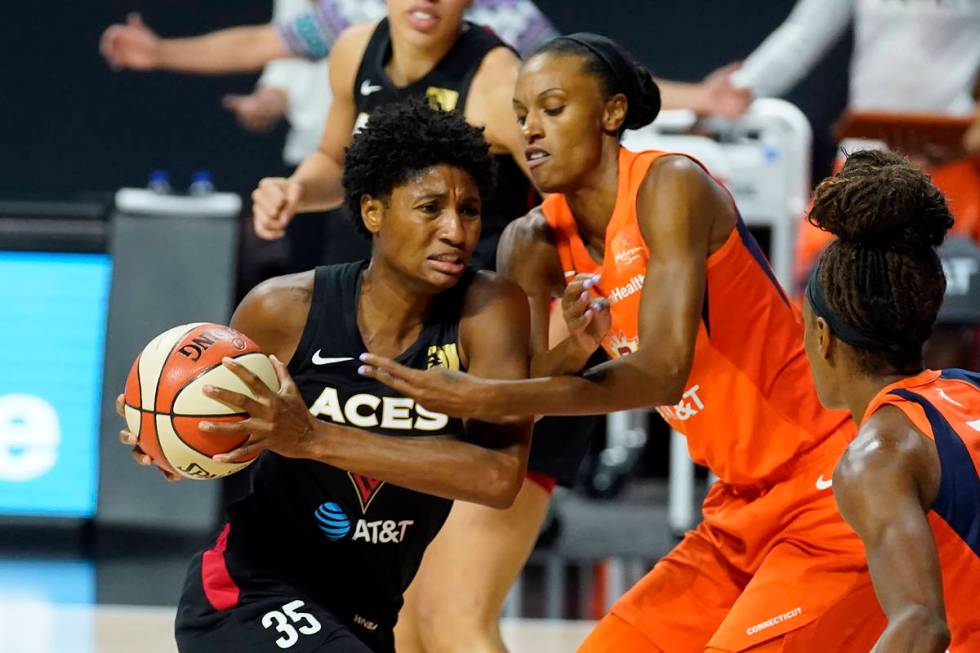 Las Vegas Aces forward Angel McCoughtry (35) drives into Connecticut Sun forward DeWanna Bonner ...