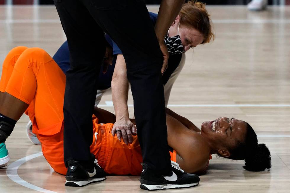 A trainer helps Connecticut Sun forward Alyssa Thomas (25) after she was hurt against the Las V ...