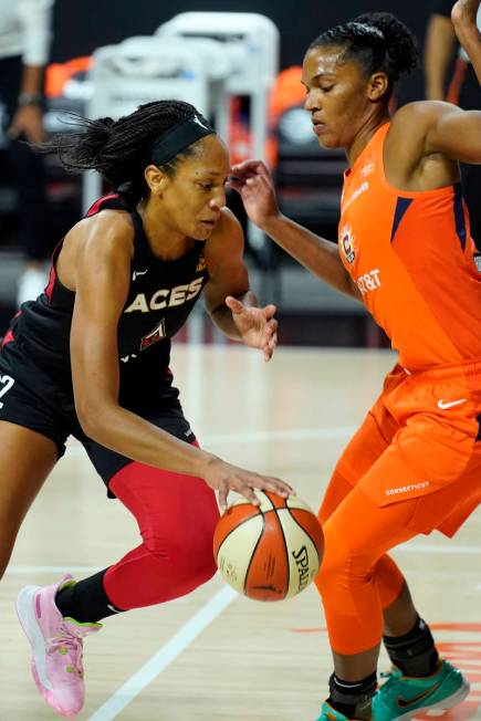 Las Vegas Aces center A'ja Wilson (22) drives against Connecticut Sun forward Alyssa Thomas (25 ...