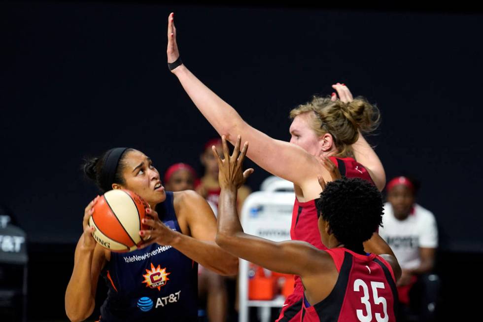 Connecticut Sun center Brionna Jones (42) goes up for a shot against Las Vegas Aces center Caro ...