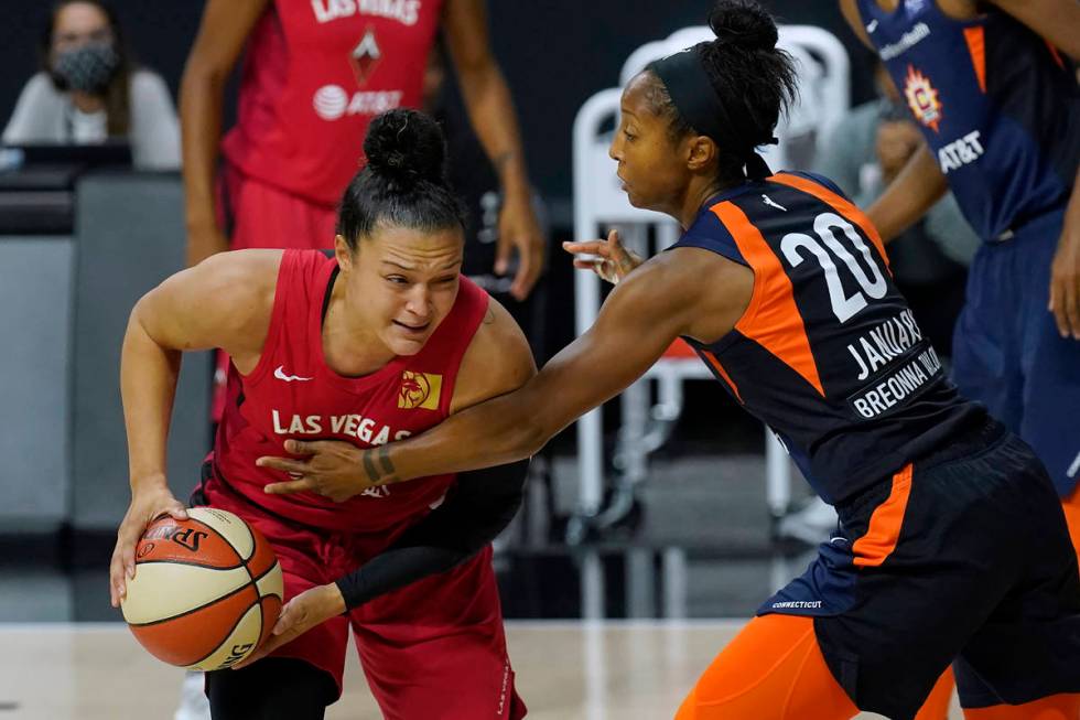 Connecticut Sun guard Briann January (20) fouls Las Vegas Aces guard Kayla McBride (21) during ...