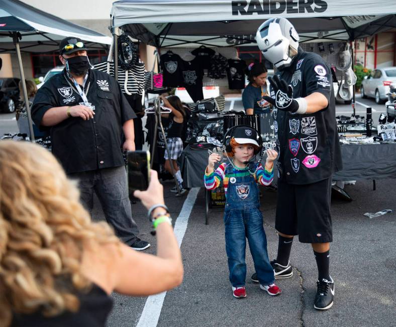 Julian Segura, 5, of Los Angeles, poses with Raider Iron Man, of Arizona, at a Raiders party at ...