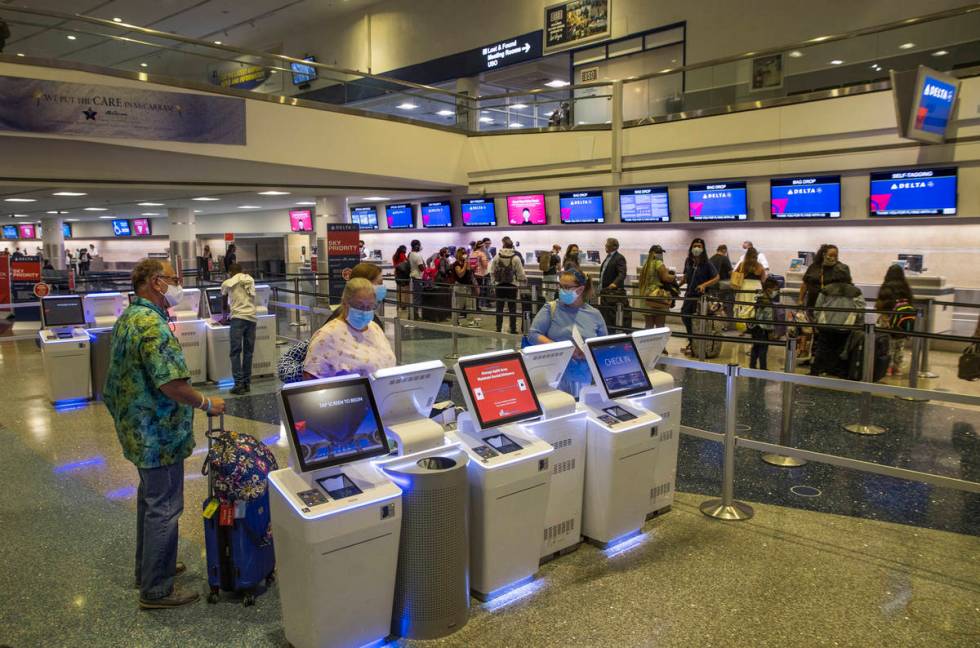 Delta Airlines customers check in machines as COVID-19 safety precautions continue at McCarran ...
